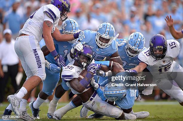 Khalid Abdullah of the James Madison Dukes drives through Jason Strowbridge and Myles Dorn of the North Carolina Tar Heels for a touchdown during the...