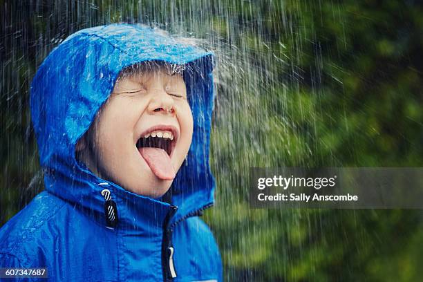 child outdoors in the rain - raincoat stock pictures, royalty-free photos & images