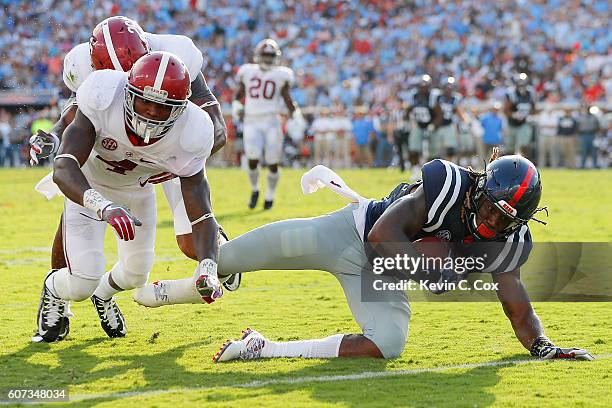 Damore'ea Stringfellow of the Mississippi Rebels is tackled at the one yard line by Eddie Jackson and Marlon Humphrey of the Alabama Crimson Tide at...