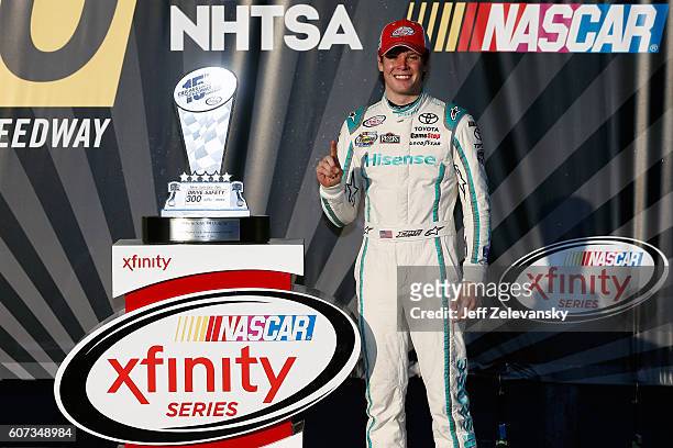 Erik Jones, driver of the Hisense Toyota, poses with the trophy in Victory Lane after winning the NASCAR XFINITY Series Drive for Safety 300 at...