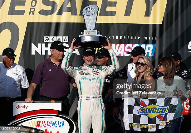 Erik Jones, driver of the Hisense Toyota, celebrates with the trophy in Victory Lane after winning the NASCAR XFINITY Series Drive for Safety 300 at...