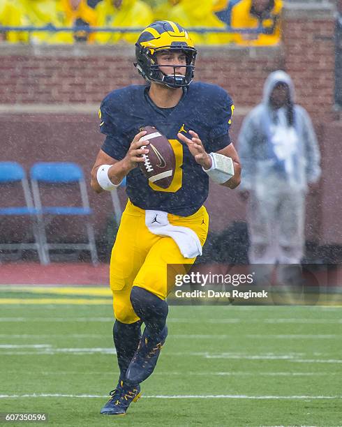 Quarterback John O'Korn of the Michigan Wolverines rolls out of the pocket and looks to make a play during a college football game against the UCF...