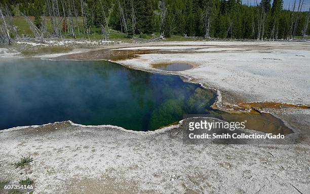 Abyss Pool and the surrounding landscape at the West Thumb Geyser Basin, Yellowstone National Park, Wyoming, June, 2015. Image courtesy Diane...