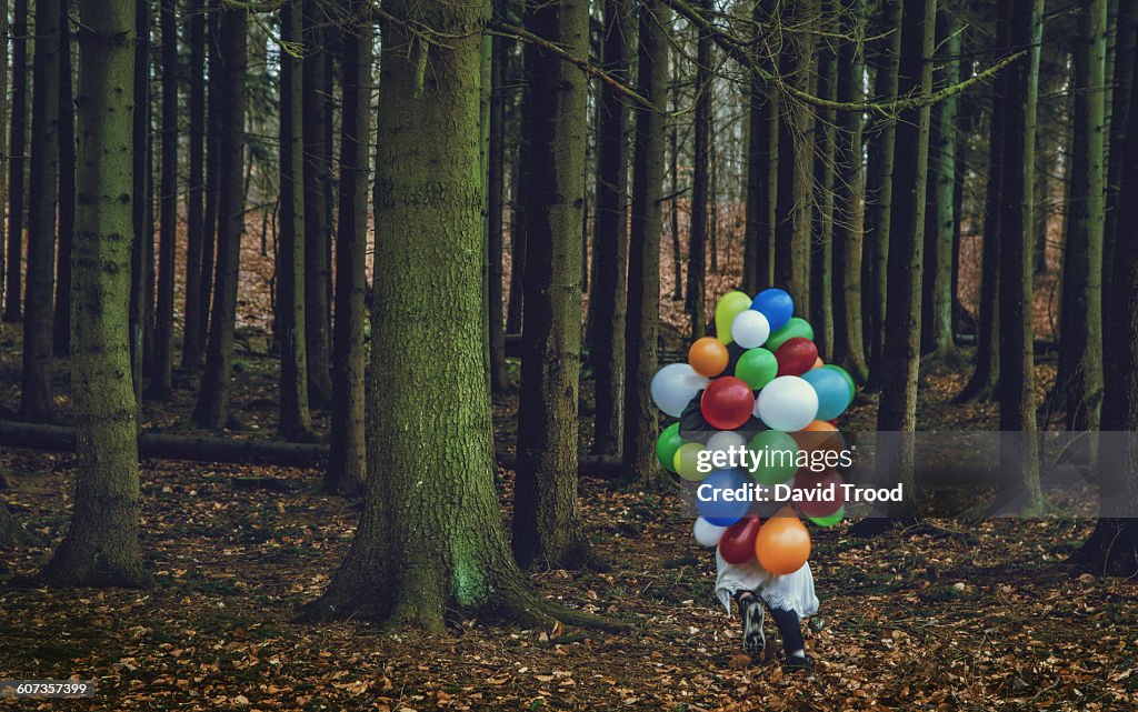 Girl covered with balloons