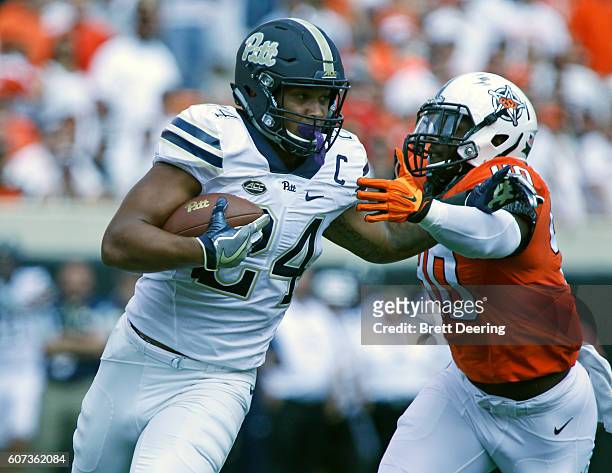 Running back James Conner of the Pittsburgh Panthers is pursued by linebacker Devante Averette of the Oklahoma State Cowboys September 17, 2016 at...