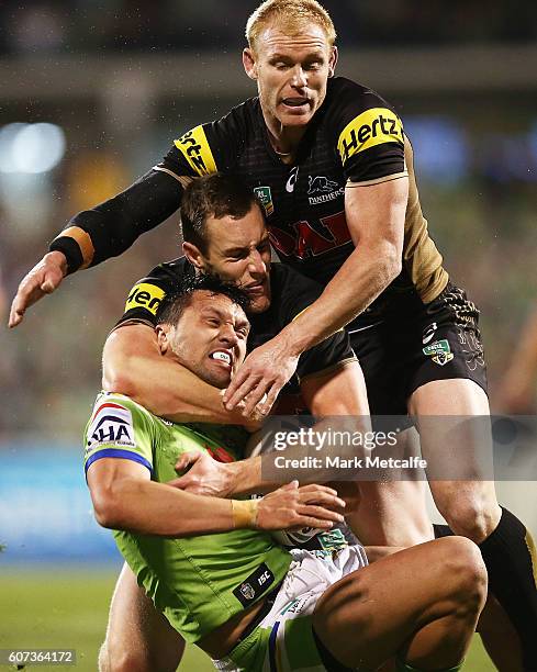 Jordan Rapana of the Raiders is tackled by Isaah Yeo and Peter Wallace of the Panthers during the second NRL Semi Final match between the Canberra...