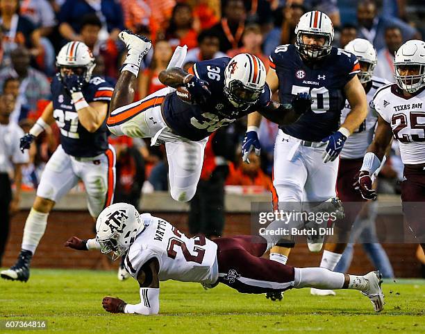 Running back Kamryn Pettway of the Auburn Tigers dives over defensive back Armani Watts of the Texas A&M Aggies as he carries the ball during an NCAA...