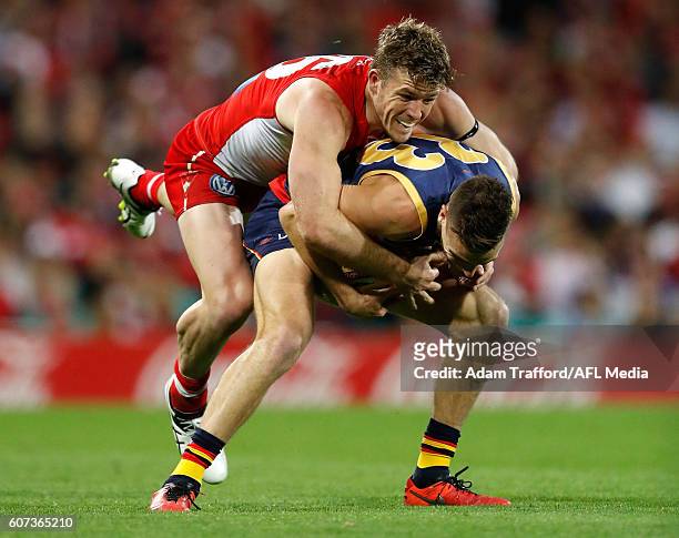 Brodie Smith of the Crows is tackled by Luke Parker of the Swans during the 2016 AFL First Semi Final match between the Sydney Swans and the Adelaide...