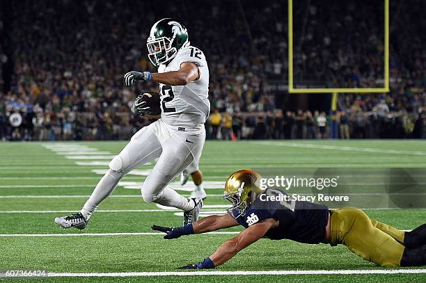 Shelton of the Michigan State Spartans scores a touchdown in front of Drue Tranquill of the Notre Dame Fighting Irish during the first half of a game...