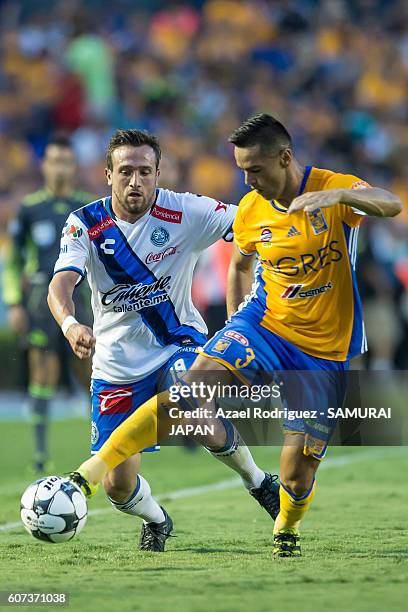 Juninho of Tigres fights for the ball with Jeronimo Amione of Puebla during the 10th round match between Tigres UANL and Puebla as part of Torneo...