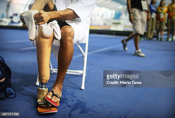 Syrian refugee swimmer Ibrahim Al Hussein adjusts his prosthetic following a practice session for media in a training pool during the Rio 2016...