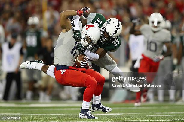 Wide receiver Nate Phillips of the Arizona Wildcats is tackled by defensive back Trayvon Henderson of the Hawaii Warriors after a reception during...