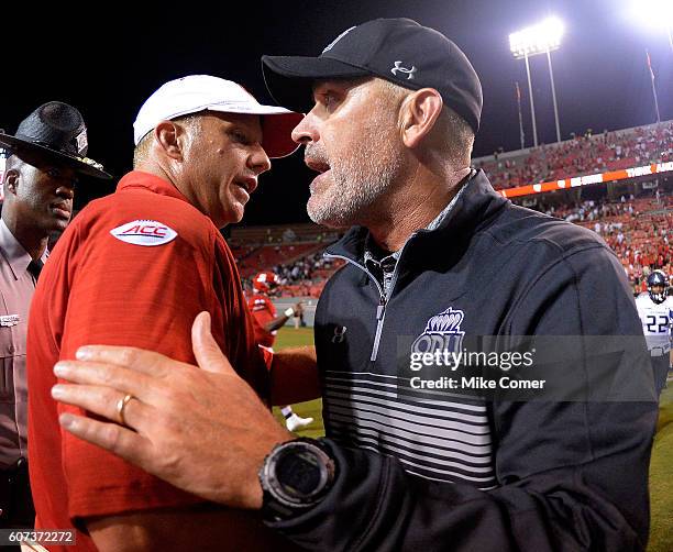 Head coach Bobby Wilder of the Old Dominion Monarchs shakes hands with head coach Dave Doeren of the NC State Wolfpack at following their game at...