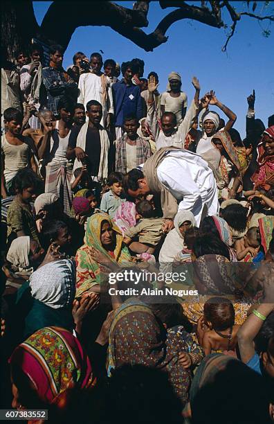 Rajiv Gandhi is surrounded by women and children during a visit to Uttar Pradesh for his legislative election campaign, leading the Congress Party,...