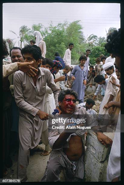 Wounded protester cries in pain and leans against bricks during a protest in Karachi after the arrest of the leader of the Pakistan People's Party,...