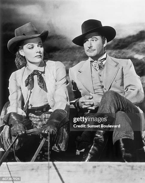 Ann Sheridan and Errol Flynn on the movie set of "Silver River" , directed by Raoul Walsh.
