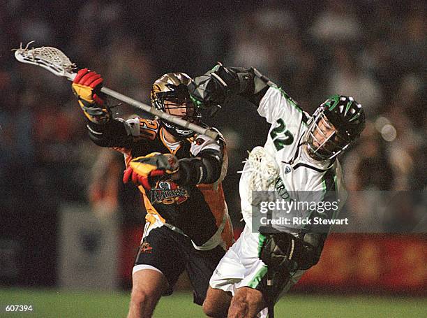 Casey Powell of the Long Island Lizards holds on to the ball while being checked by Steve Bishko of the Rochester Rattlers in their Major League...