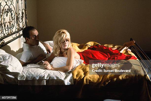 French actors Michel Piccoli and Brigitte Bardot on the set of Le Mepris , written and directed by Swiss-French director Jean-Luc Godard.