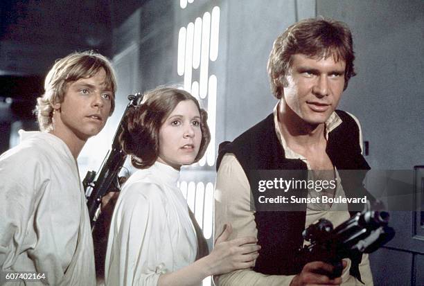 American actors Mark Hamill, Carrie Fisher and Harrison Ford on the set of Star Wars: Episode IV - A New Hope written, directed and produced by...