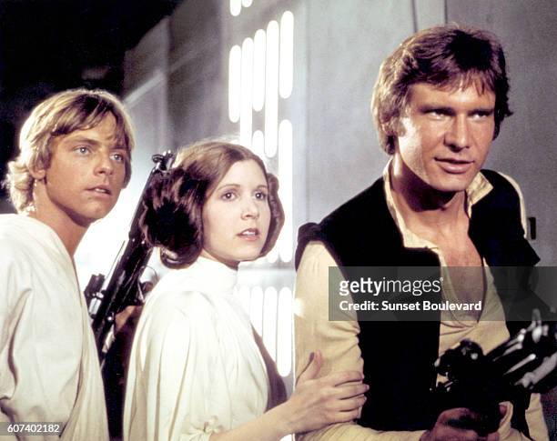 American actors Mark Hamill, Carrie Fisher and Harrison Ford on the set of Star Wars: Episode IV - A New Hope written, directed and produced by...