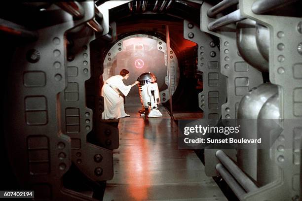 American actress Carrie Fisher and British actor Kenny Baker on the set of Star Wars: Episode IV - A New Hope written, directed and produced Georges...