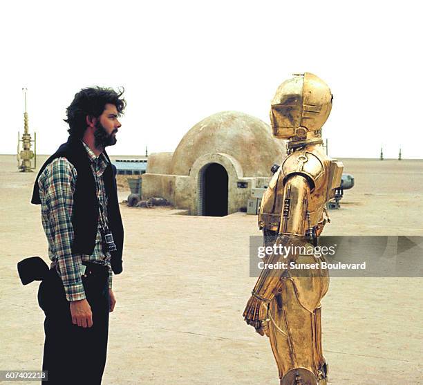 British actor Anthony Daniels with American director, screenwriter and producer George Lucas on the set of his movie Star Wars: Episode IV - A New...