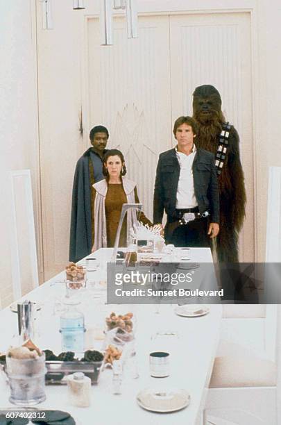 American actors Billy Dee Williams, Carrie Fisher, Harrison Ford and British Peter Mayhew on the set of Star Wars: Episode V - The Empire Strikes...