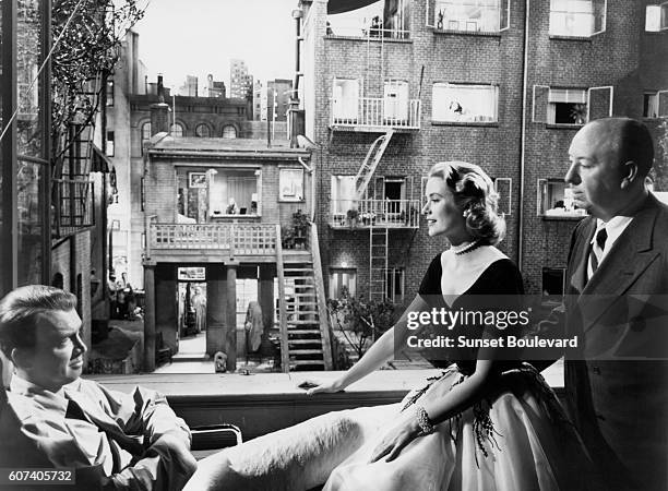 American actors Grace Kelly and James Stewart with British director and producer Alfred Hitchcock on the set of his movie Rear Window.