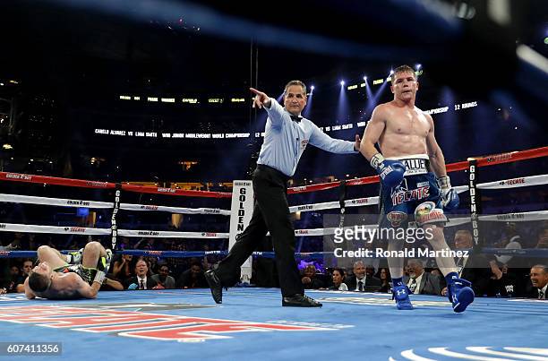 Canelo Alvarez, right, is lead to his corner after knocking down Liam Smith, left, during the WBO Junior Middleweight World fight at AT&T Stadium on...