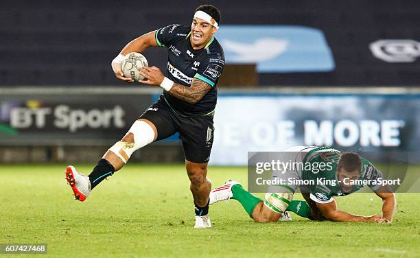 Josh Matavesi of Ospreys evades the tackle of Guglielmo Zanini of Benetton Treviso during the Guinness PRO12 Round 3 match between Ospreys and...