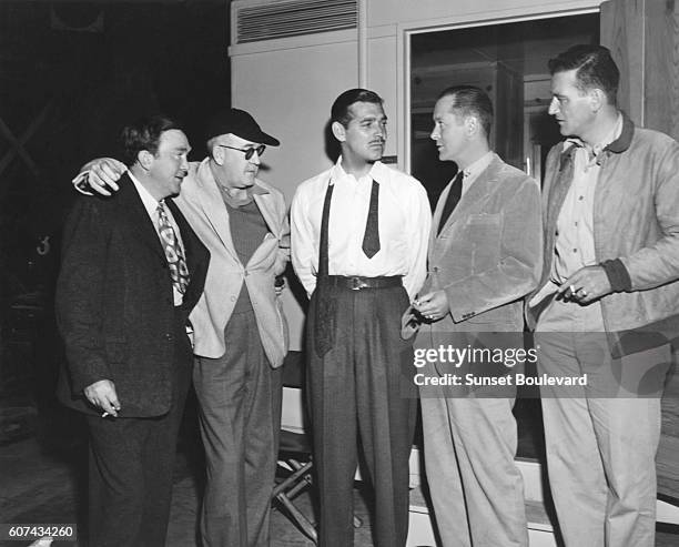 View of, from left, American actor Thomas Mitchell , film director John Ford , and actors Clark Gable , Robert Montgomery , and John Wayne as they...