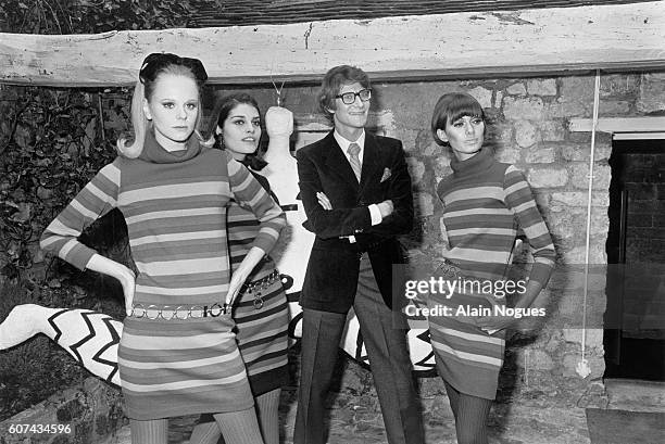 French fashion designer Yves Saint Laurent with three of his fashion models wearing minidresses during the inauguration of the first Yves Saint...