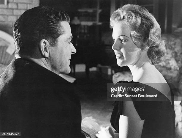 American actor Dana Andrews and Welsh-born Irish actress Peggy Cummins on the set of Night of the Demon, directed by Jacques Tourneur.