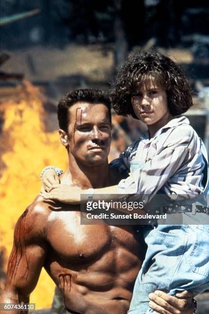 Austrian-born American actor Arnold Schwarzenegger and American actress Alyssa Milano on the set of Commando, directed by Mark L. Lester.