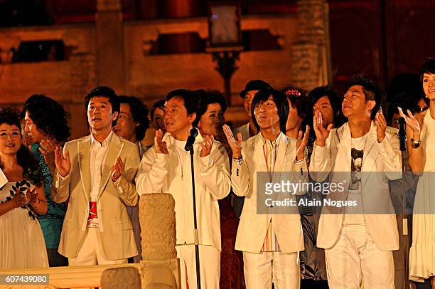 Chinese entertainment stars sing the official Beijing 2008 song outside the Working People's Cultural Palace during the ceremony celebrating the...
