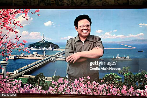 Poster of leader Kim Jong Il against backdrop a a dam.