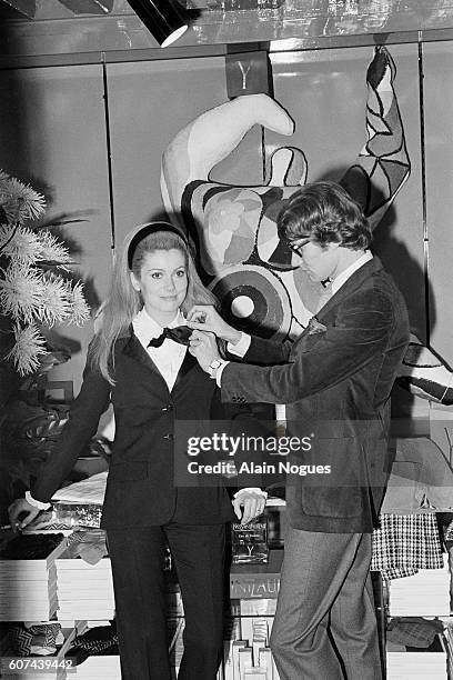 French actress Catherine Deneuve models an outfit for French fashion designer Yves Saint Laurent.