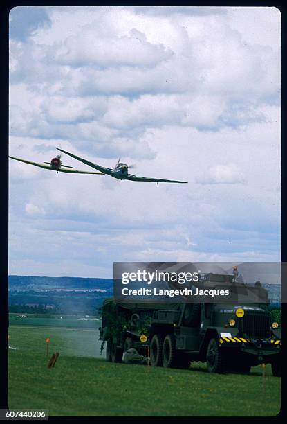 As part of Normandy's World War II fighter plane air show , participants reenact an attack on a military convoy by two German Messersmit planes. |...