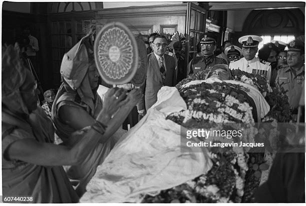 Two monks chant and perform a religious rite next to the body of Indira Gandhi, which lies in state following her assassination on October 31, 1984....
