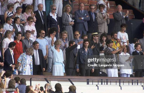 Princess Diana and Prince Charles wave from the crowd during the Live Aid concert held in London. The 1985 concert was held simultaneously at JFK...