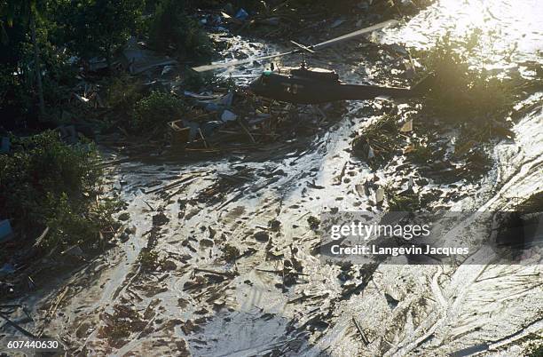 Helicopter flies over a lahar from the erupting Nevado del Ruiz volcano in Colombia. The 1985 eruption completely destroyed the town of Armero and...