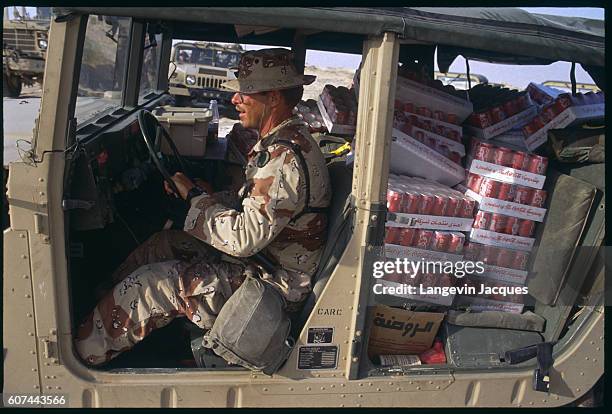 An American soldier drives a jeep full of Coke cans. They are part of a whole Coca-Cola shipment made to the 82nd Airborne Division deployed west of...