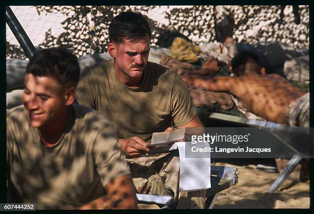 American soldiers relax with a card game while stationed in Saudi Arabia during Operation Desert Shield. Iraqi president Saddam Hussein invaded...