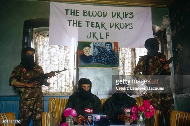 Jafan Kashmiri , and Altaf Ahamd, commander in chief of the Jammu Kashmir Liberation Front sit protected by two armed guards. The banner overhead...