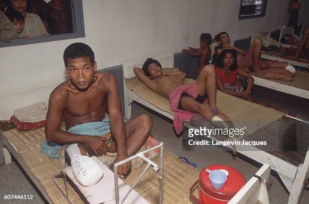 Cambodian land mine victims with amputated legs wait on cots in a primitive hospital ward. French soldiers of the Foreign Legion, intervening through...