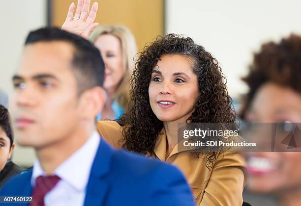 confident woman asks question during meeting - diverse town hall meeting stock pictures, royalty-free photos & images