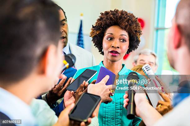 african american female political candidate surrounded by reporters - local government official stock pictures, royalty-free photos & images