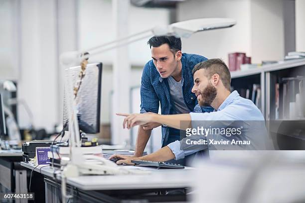 industrial designers at the office discussing project on the computer - architect stock pictures, royalty-free photos & images