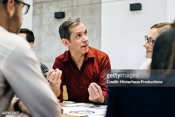 mature man speaking in a business meeting. - unternehmen stock-fotos und bilder