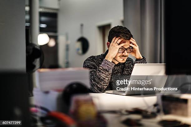 young businessman holding his head and pondering - beschaulichkeit stock-fotos und bilder